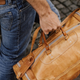 A man carries a duffle bag by the handles